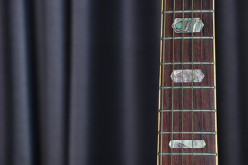 Close up acoustic guitar with curtain background, Detail of musical instruments