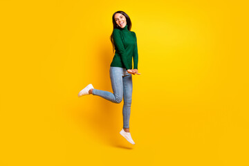 Fototapeta na wymiar Full length photo of adorable happy young woman jump up air good mood smile weekend isolated on yellow color background