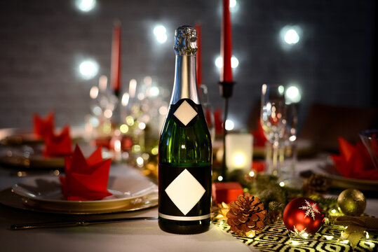 champagne bottle on a christmas holiday festive party table with wine glass on a red and gold shiny decoration