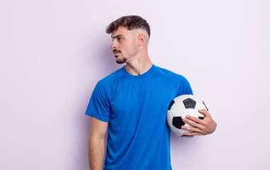 young handsome man on profile view thinking, imagining or daydreaming. soccer concept