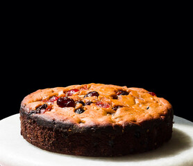 Closeup of traditional Christmas fruit cake, isolated on black background.