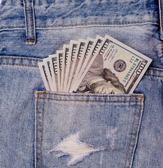 Cash, money is in the pocket of blue jeans. Money in pocket. Man hand is putting money in the pocket. Dollars.