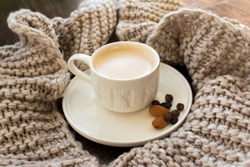 Cup of coffee in a beige scarf
