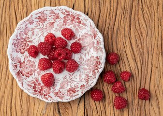 Raspberries in a plate over wooden table