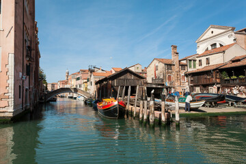 View of water canals and the Squero, gondola boatyard with repairing workers