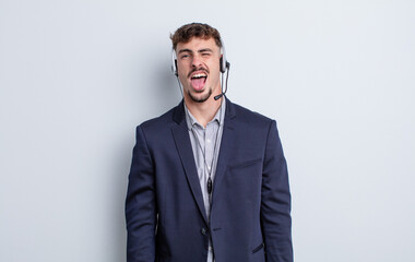 young handsome man with cheerful and rebellious attitude, joking and sticking tongue out....