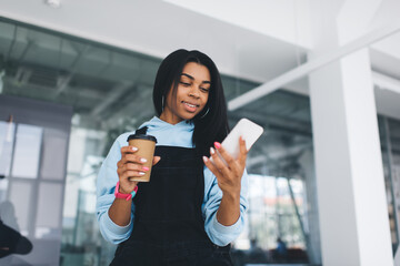 Black girl using mobile phone and drinking coffe