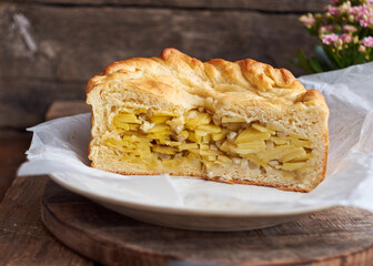 Homemade potato pie. Yeast dough. Wooden background, side view.