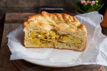 Homemade potato pie. Yeast dough. Wooden background, side view.