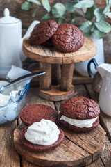 Ice Cream Sandwices: Vanilla ice cream sandwiched between two chocolate cookies on a wooden board on a wooden background.