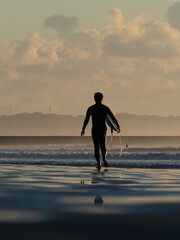 surfer on the beach at sunset