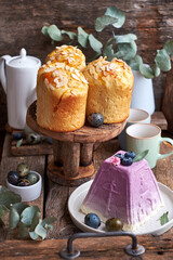 Easter cake with almond chips and Traditional Easter Orthodox curd cake with blueberry.  Wooden background, side view
