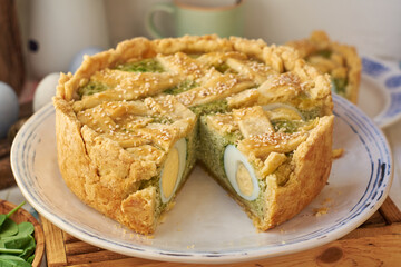 Easter pie with spinach, egg and cottage cheese. White background, side view