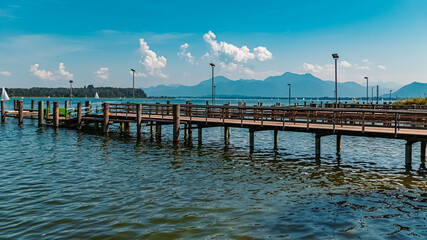 Beautiful alpine summer view with a pier and the alps in the background at the famous Chiemsee, Bavaria, Germany