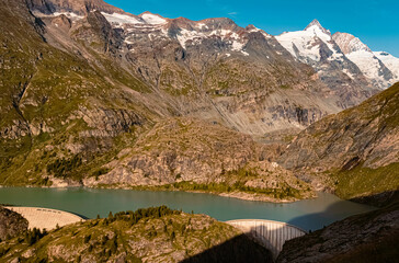 Naklejka na ściany i meble Beautiful alpine summer view with a reservoir and the famous Grossglockner summit in the background at the famous Grossglockner high Alpine road, Kaernten, Salzburg, Austria