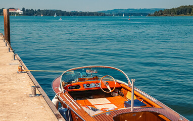 Fototapeta na wymiar Beautiful alpine summer view with a small wooden boat at the famous Chiemsee, Bavaria, Germany