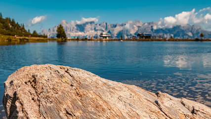 Beautiful alpine summer view with details of a rock and the famous Dachstein mountains in the background at the Reiteralm, Pichl, Schladming, Steiermark, Austria