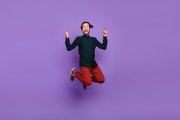 Fototapeta na wymiar Photo of funky lucky young guy dressed smart casual clothes writing modern gadget jumping high smiling isolated violet color background