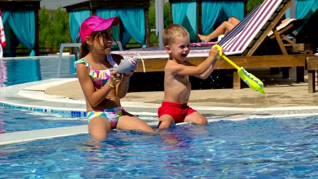 Children in the pool splashing water. Selective focus.