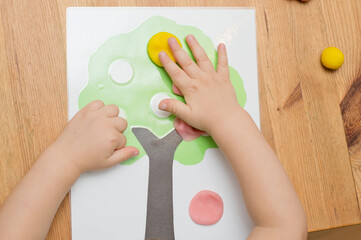 Boy is playing with a model. Glue colored apples and glue on wood. Montessori materials....