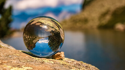 Crystal ball alpine landscape shot with reflections and the famous Dachstein mountains in the background at the Spiegelsee, Reiteralm, Pichl, Schladming, Steiermark, Austria