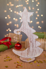 Wooden white Christmas tree on a background of lights. Christmas. Souvenir. New Year Postcard