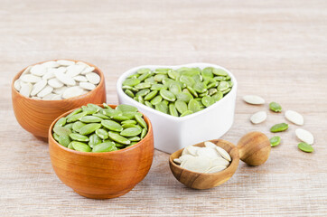 Pumpkin seeds green and unpeeled in wooden bowl.
