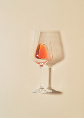 Minimal flat lay composition with rose vine glass on bright cream background.