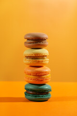 Close up colorful macaroons isolated on yellow background.