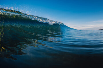 Fototapeta na wymiar Perfect glassy wave in sea. Crashing surfing wave and sky