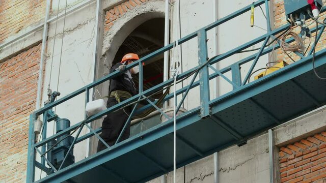 Industrial workers welding metal structures, male welders brazing a steel beam on a new building at a construction site. the welder is working. Sparks fly like a welder welds steel. builder