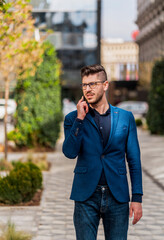 Urban guy wearing stylish clothing having phone conversation