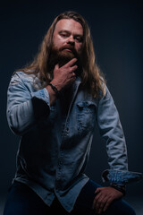 Close up portrait of handsome manly guy with beard posing in studio on a isolated background.