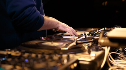 Hip hop dj scratching vinyl records on turntables on party in night club. Professional disc jockey...