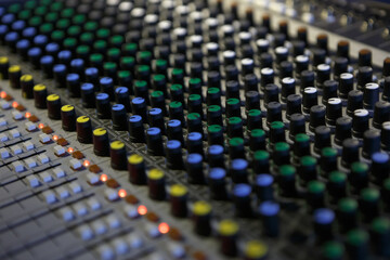 Professional audio mixer panel with volume regulators and faders. Sound mixing console on concert...