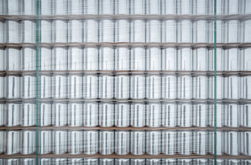 Aluminum cans for drinks stacked on shelf in warehouse. New unused aluminium for cold beverages