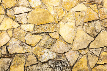 Background of dark yellow orange rough stone wall texture horizontal photo