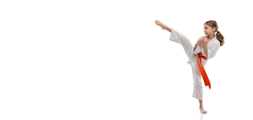 Portrait of little girl, young karate training alone isolated over white background. Concept of sport, education, skills © master1305