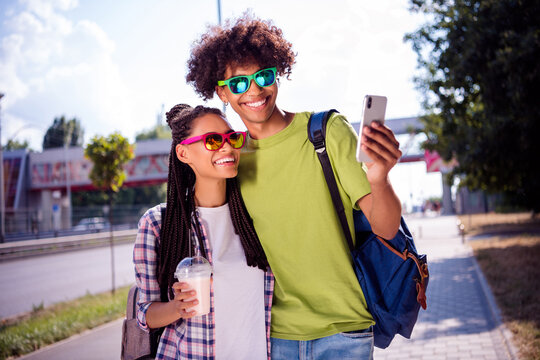 Portrait of attractive cheerful carefree couple spending free time sunny day taking making selfie summertime outdoors