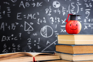 School books on desk infront of blackboard with formulas. education concept