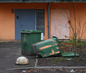 Green plastic dumpsters at the front door of the house