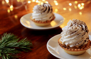 two tasty tartlets with whipped cream sprinkled with cocoa