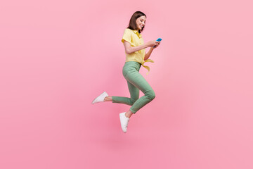 Fototapeta na wymiar Full body profile side photo of young girl happy smile post comment cellphone jump up isolated over pink color background