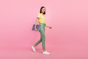 Full body profile side photo of young girl happy positive smile go walk meeting laptop isolated over pink color background