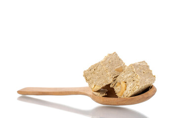 Two pieces of halva with peanuts with a wooden spoon, close-up, isolated on white.