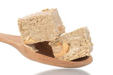 Two pieces of halva with peanuts with a wooden spoon, close-up, isolated on white.