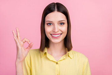 Photo of young girl happy positive smile show okay alright symbol great perfect fine isolated over pink color background