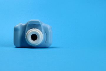 plastic toy camera for children on a blue background. Copy space for text
