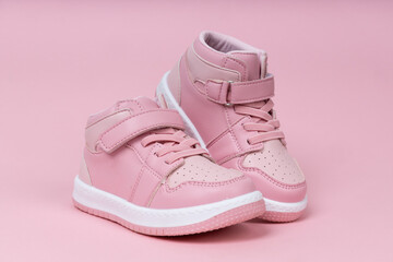 Pink child shoes on pink background. Cute children's shoes for girls