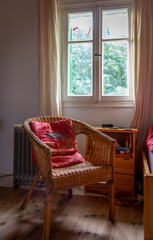 A homely comfortable warm interior with a comfortable chair by the window for relaxation.